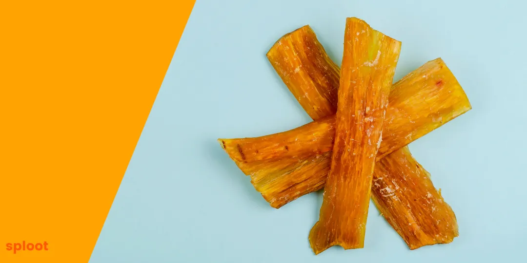 Four crossed dried meat strips on a blue and orange background