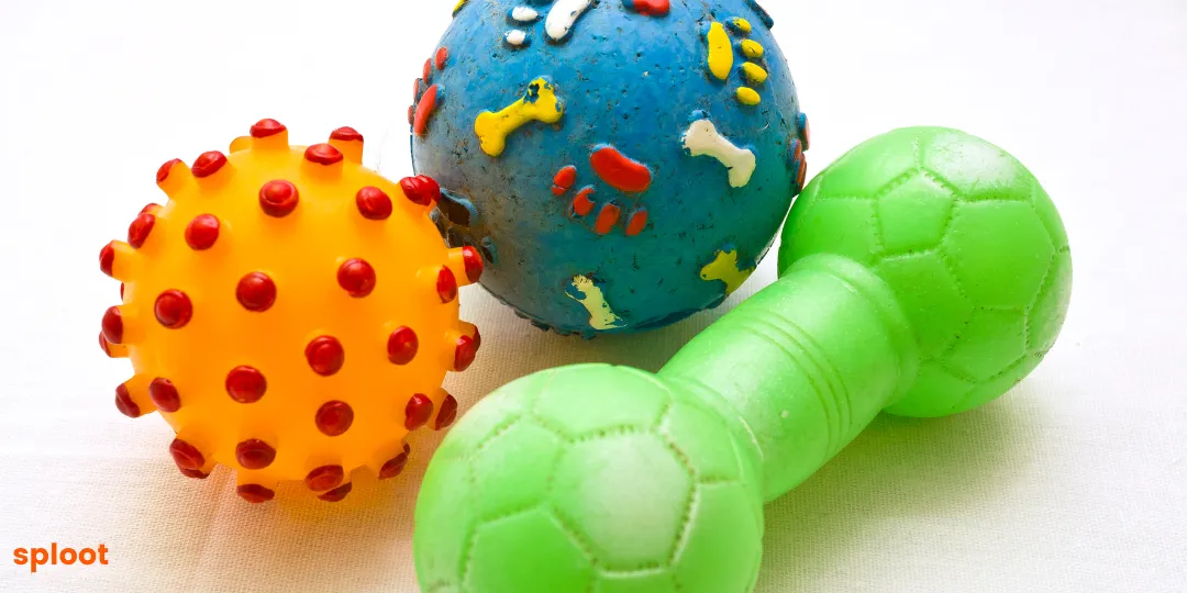 Orange spiky ball, blue paw-print ball and green dumbbell rubber toys