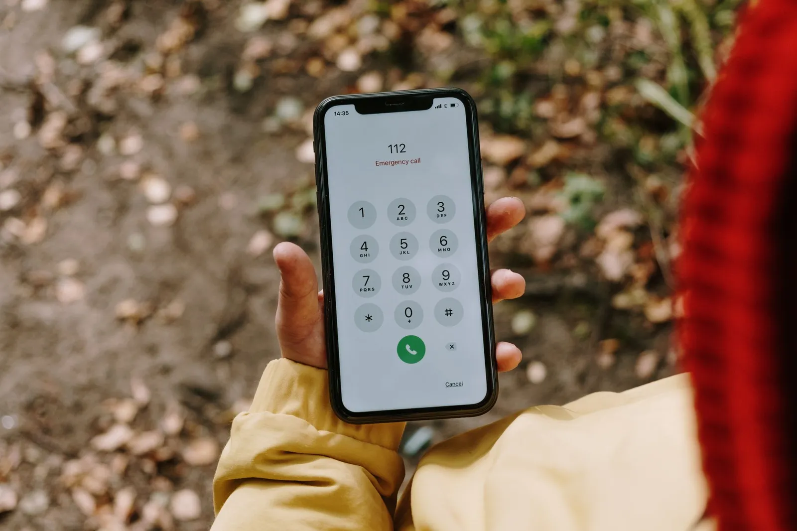 Hand holding a phone with an emergency number dialed