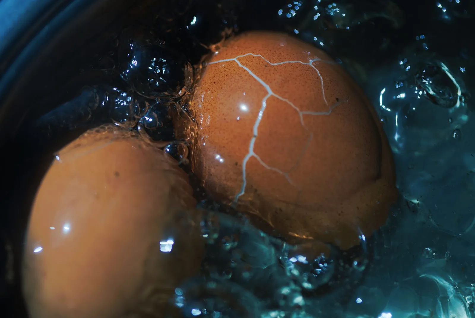 Eggs boiling in a kitchen pot without oil or seasoning
