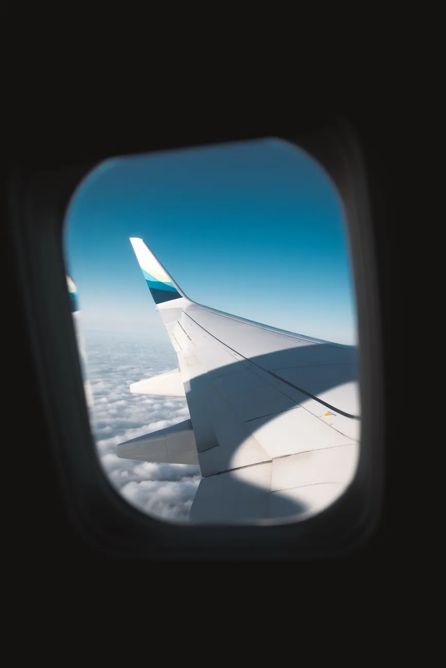 Airplane wing and sky seen from a cabin window