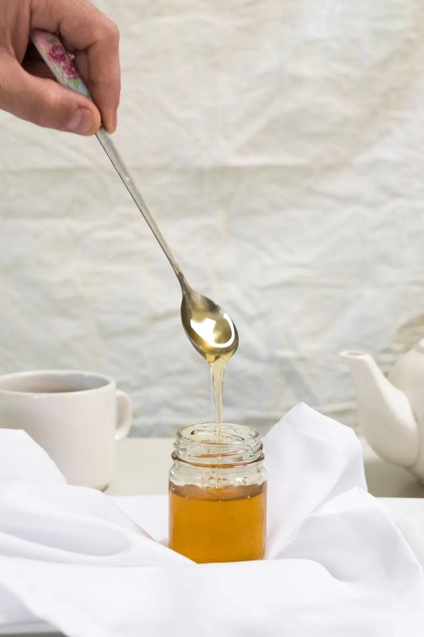 Jar of honey and spoon used only for adult dog cough comfort