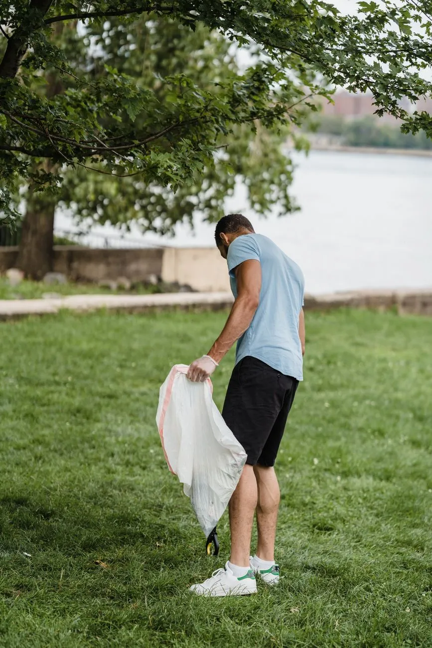Person cleaning a public park path after litter