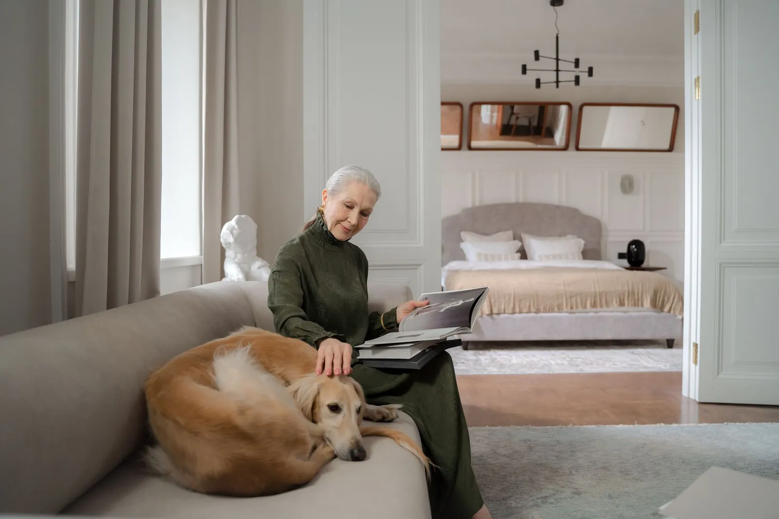 Person sitting with a dog on a sofa at home