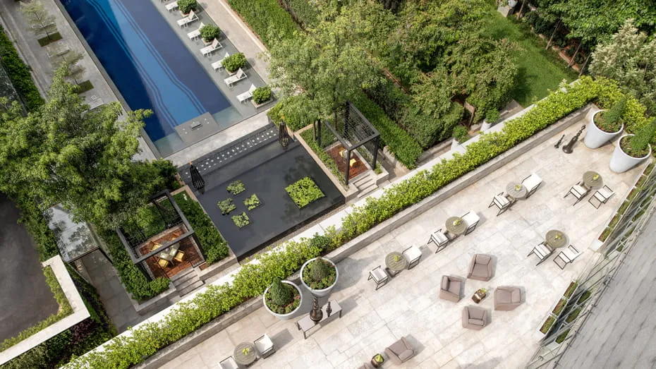 Aerial view of a hotel pool deck with lounge chairs and garden seating