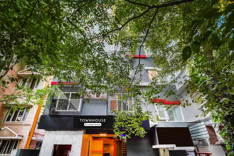 Townhouse building entrance sign seen through overhanging tree branches