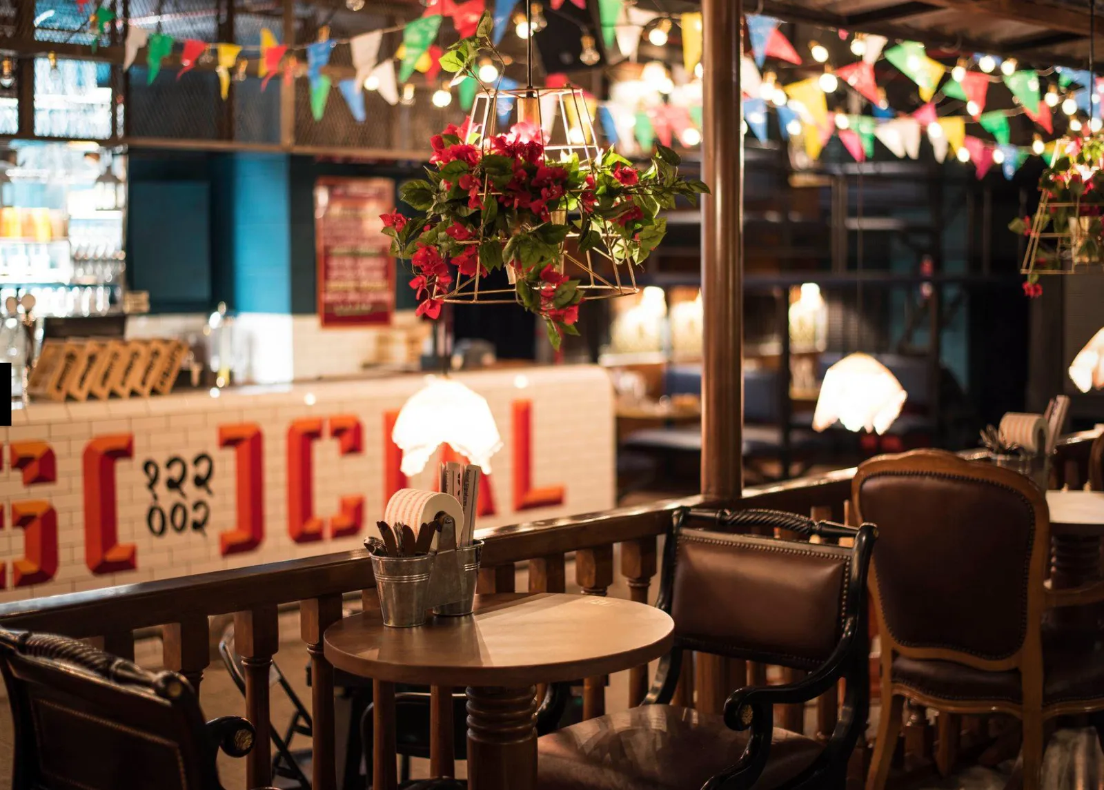 Indoor seating area decorated with colourful bunting and hanging lights