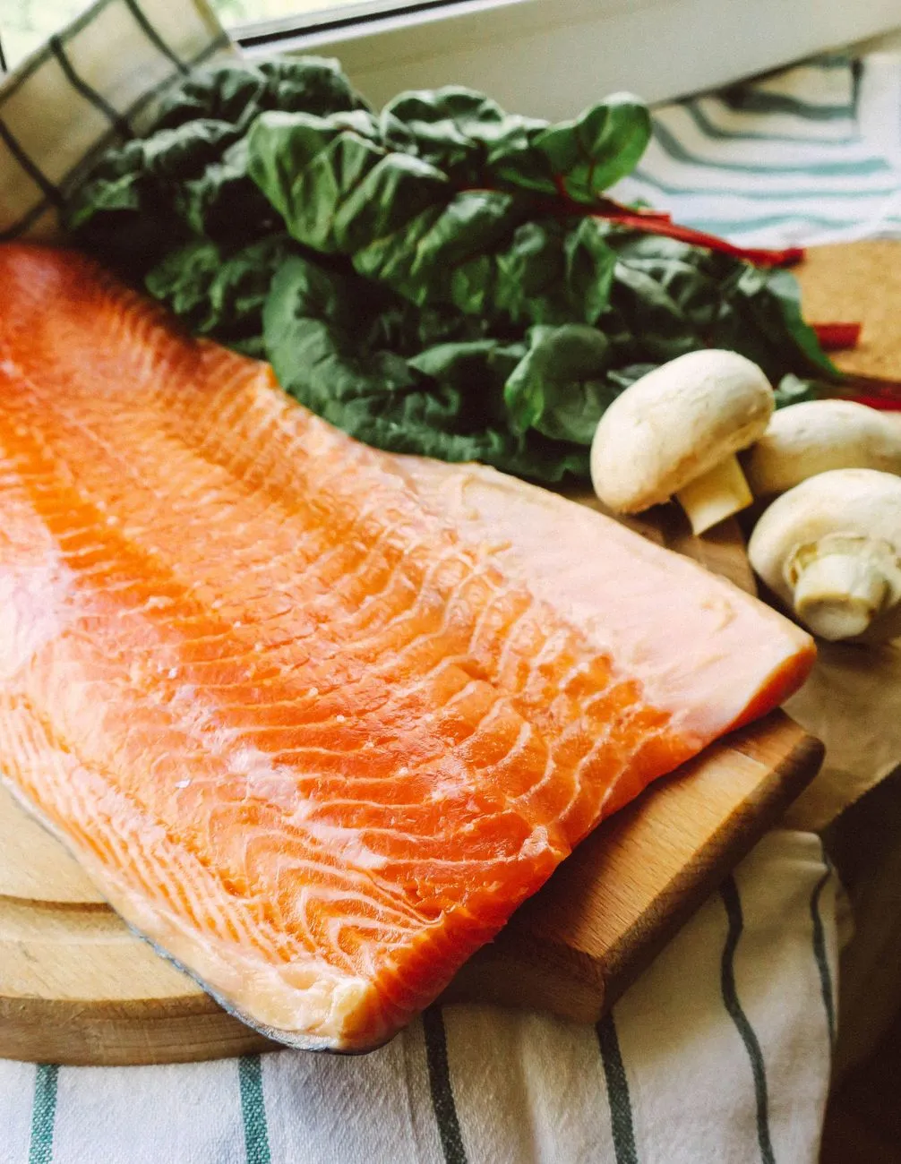 Fresh fish fillet and vegetables arranged as dog meal ingredients