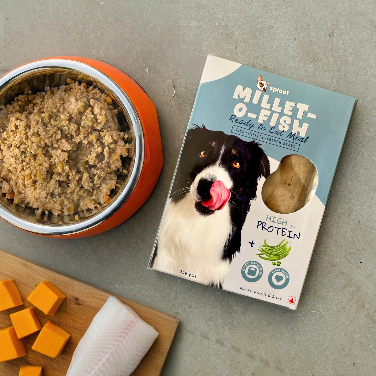 Sploot Millet-O-Fish fresh dog food pack beside a bowl of the cooked fish meal, fish fillet and pumpkin