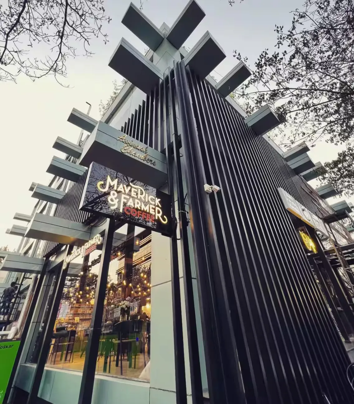 Storefront signage of Maverick and Farmer Coffee against a tree-lined street
