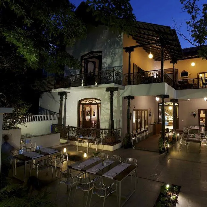 Heritage-style building at Sunny's with outdoor dining tables lit up at dusk