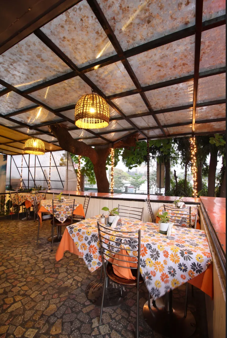 Covered rooftop seating at Urban Solace with floral tablecloths and hanging lights