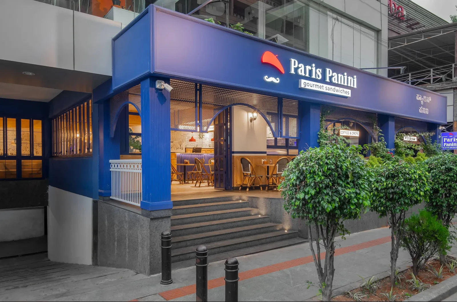 Blue storefront exterior of Paris Panini gourmet sandwiches with entrance steps
