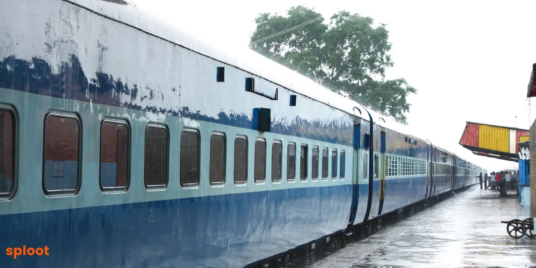 Indian Railways train coach standing at a rainy platform